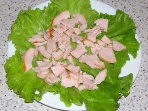 кусочки копчёной курицы на листьях салата