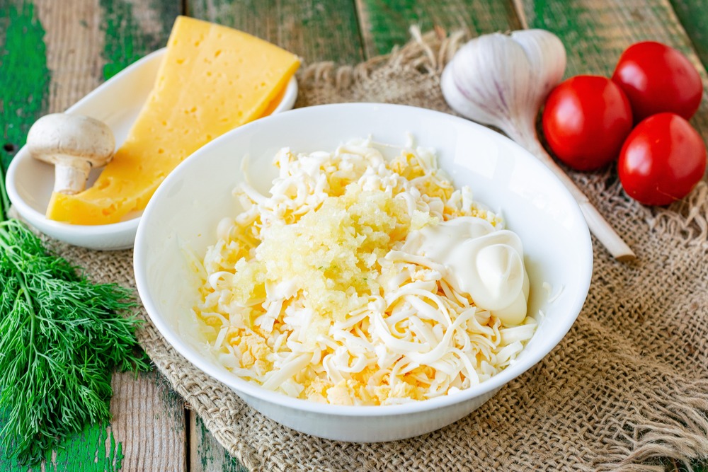 Смешиваем тертые яйца, плавленый сыр, чеснок и майонез