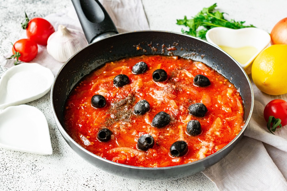 Всыпаем в соус маслины, солим и приправляем ингредиенты специями